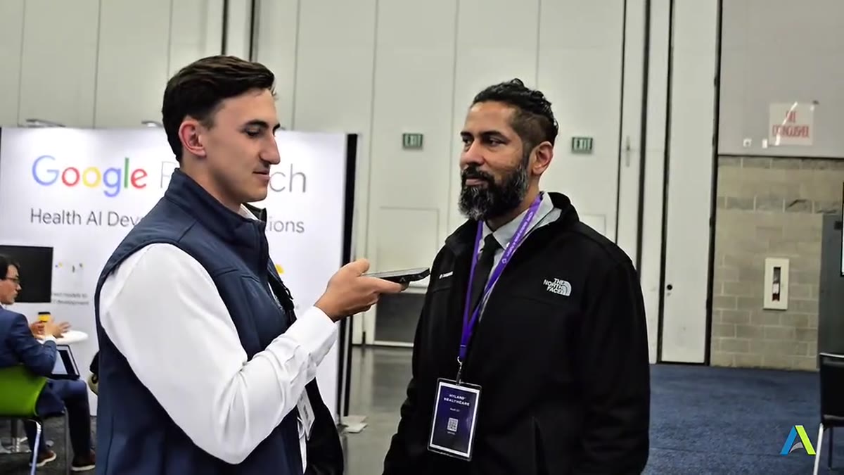 Two people running a live Voice AI demo on a phone at SIIM 2025