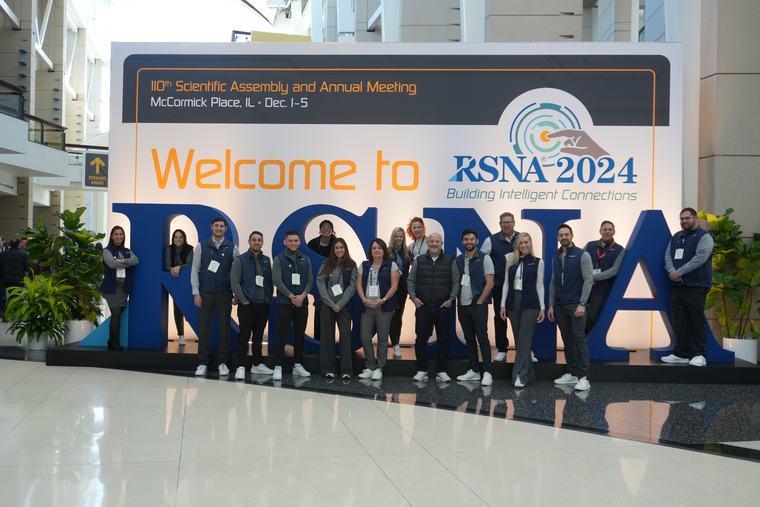 The AbbaDox team in front of the Welcome to RSNA 2024 sign at McCormick Place