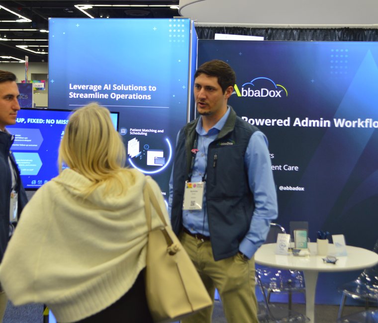 An AbbaDox specialist in conversation with a visitor at the stand at SIIM 2025